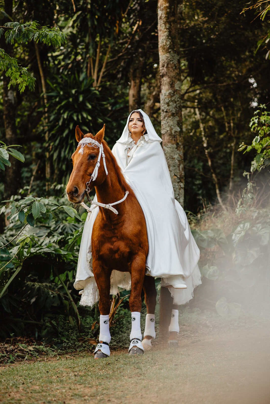 entrada da noiva com capa em cima de cavalo no campo