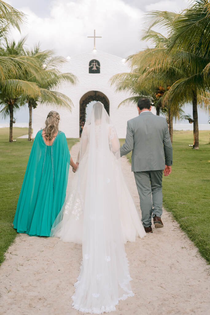 entrada da noiva ao lado da mãe com vestido turquesa e pai com terno cinza