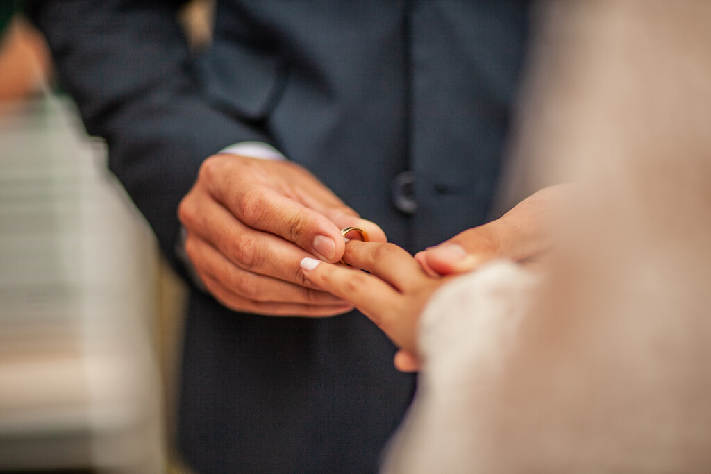 noivo colocando a aliança na mão da noiva