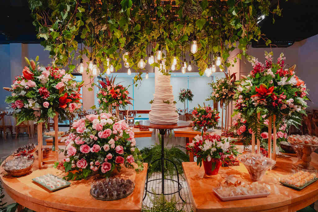 salão com mesa do bolo com flores rosas