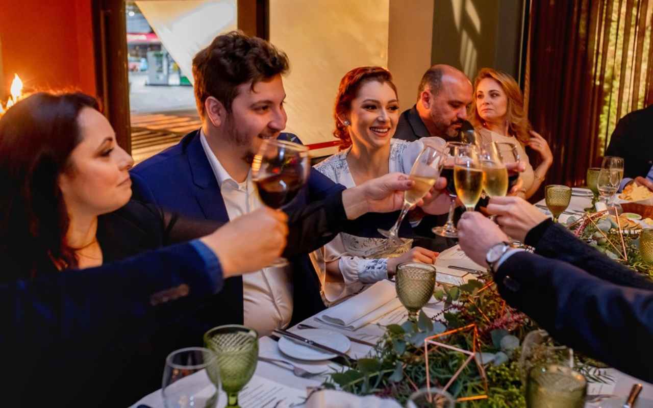 noivos brindando com convidados em casamento no restaurante