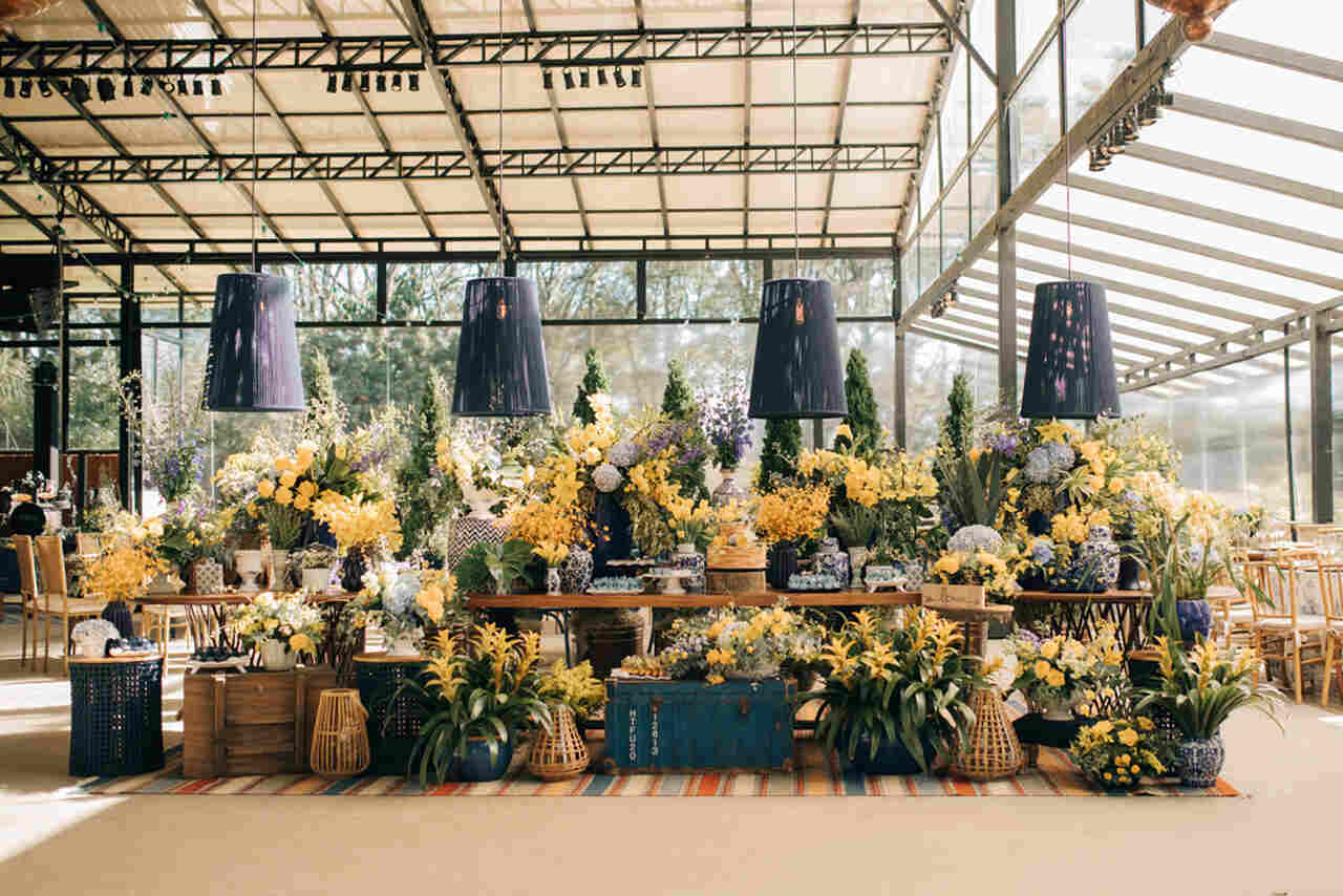 Mesa do bolo e doces com muitas plantas - flores amarelas e folhagens