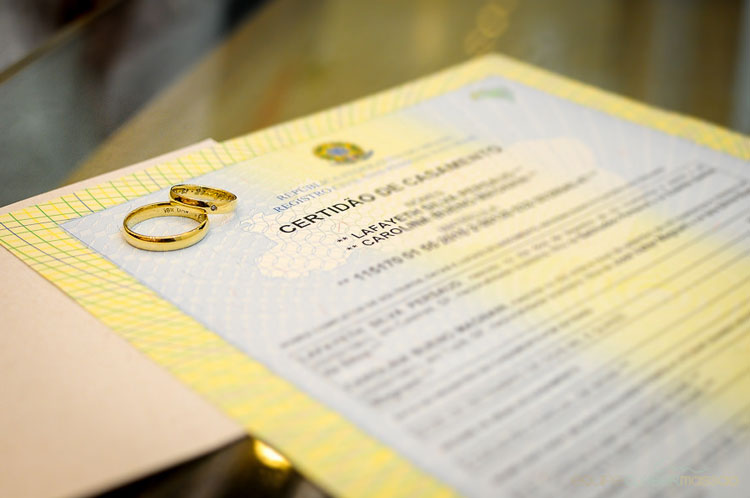 Certidão de casamento com as alianças sobre ela