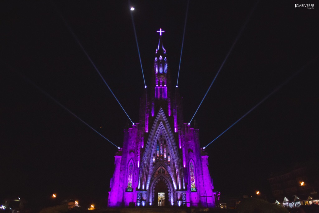 Catedral de Pedra, iluminada com luz roxa à noite.