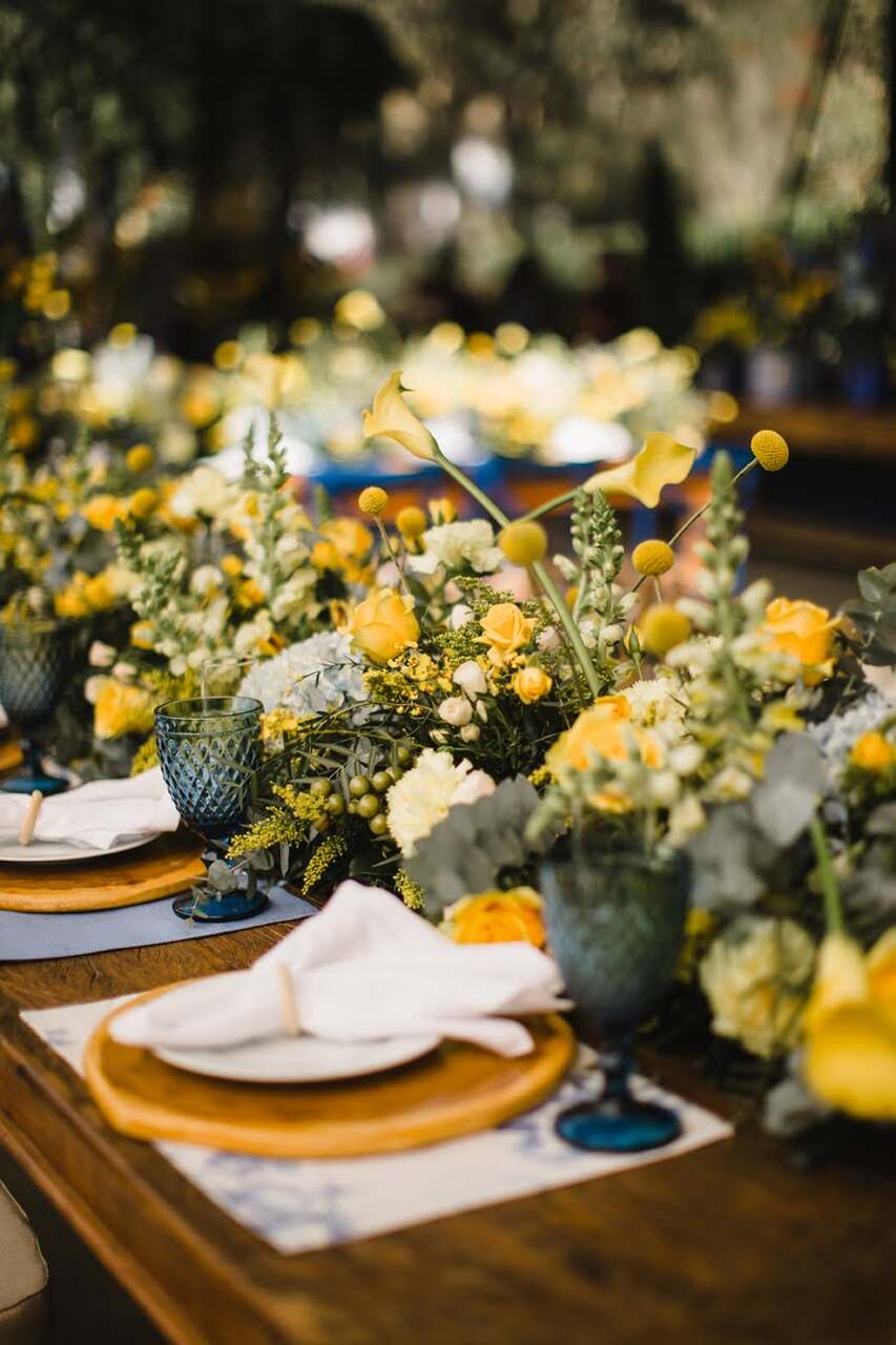 Mesa dos convidados com arranjos florais amarelos