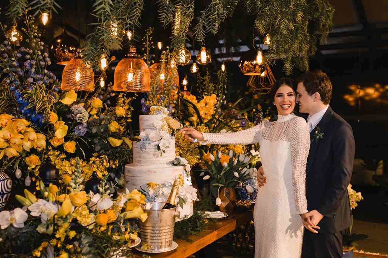 Casal abraçados cortando o bolo 