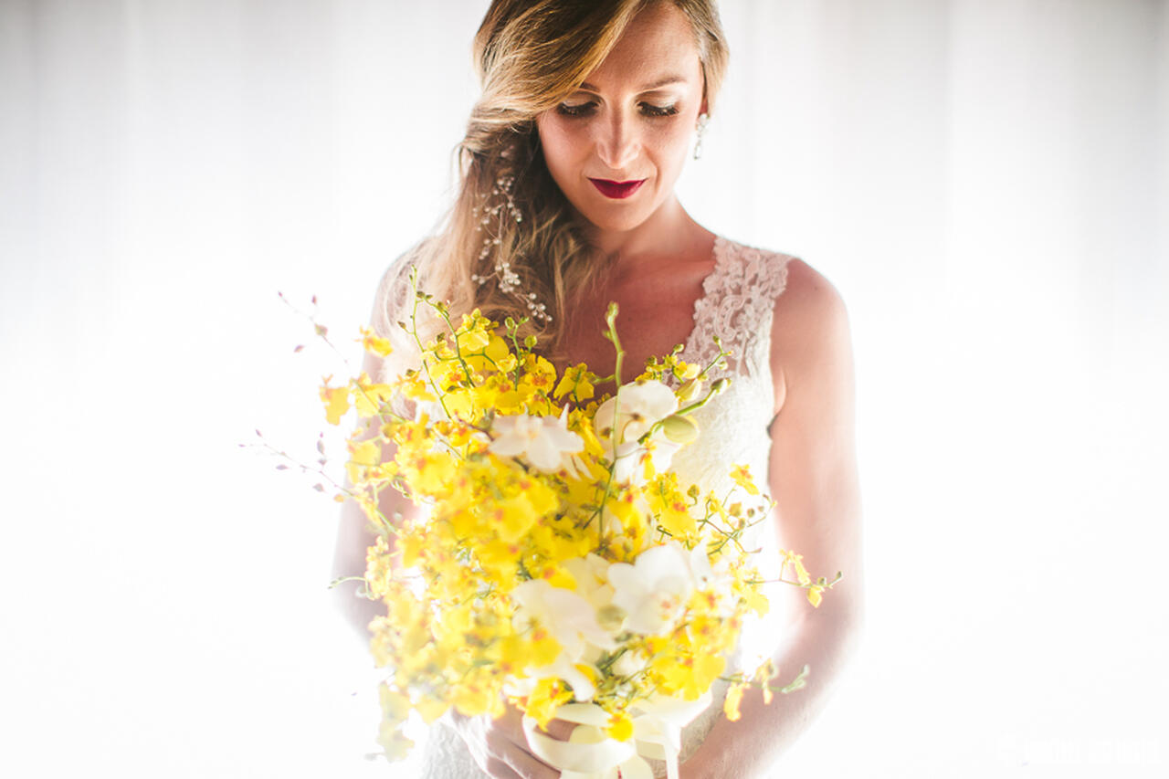 Noiva segurando um buquê com flores amarelas