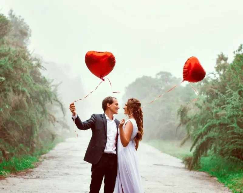 casal segurando balões de coração para bodas de 5 anos 