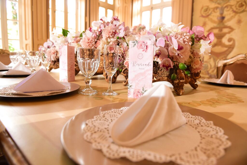 mesa posta com orquideas cor de rosa no centro