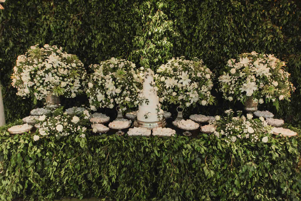 mesa com bolo de casamento clássico com arranjos com flores brancas