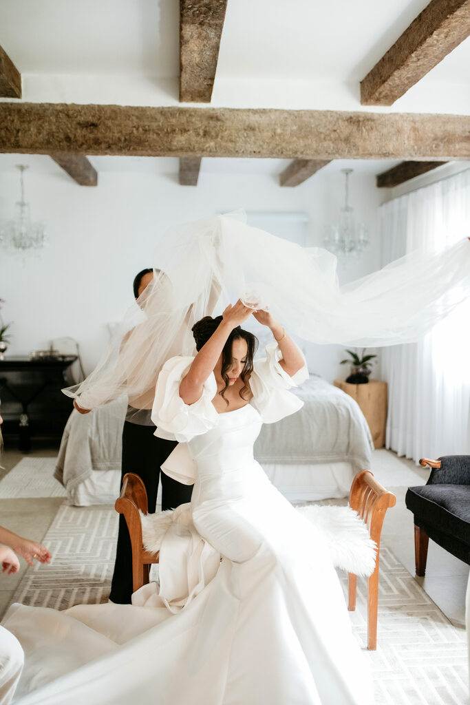 mulher colocando véu na noiva