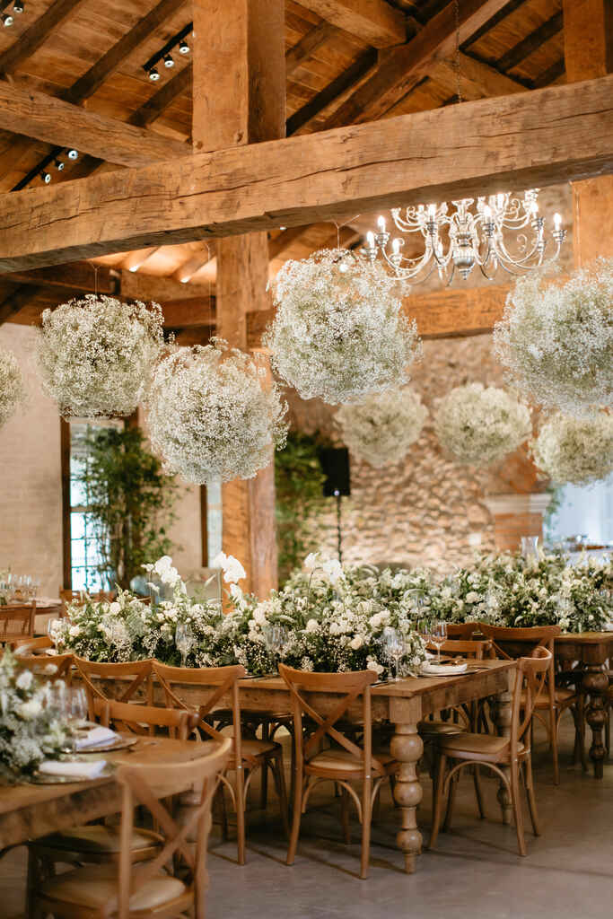 salão com mesas decoradas com flores brancas e aéreos com flores mosquitinho