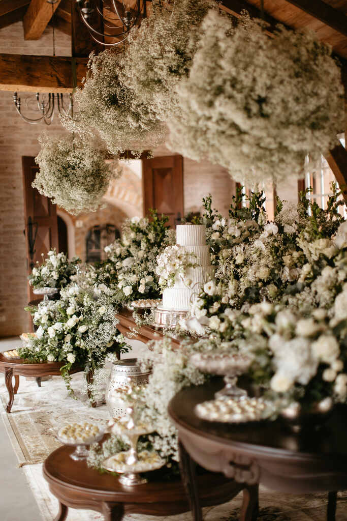 mesa clássica de madeira com plantas rosas brancas e flores mosquitinho