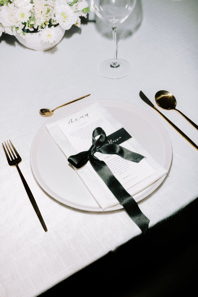 mesa posta com convite decorado com laço preto