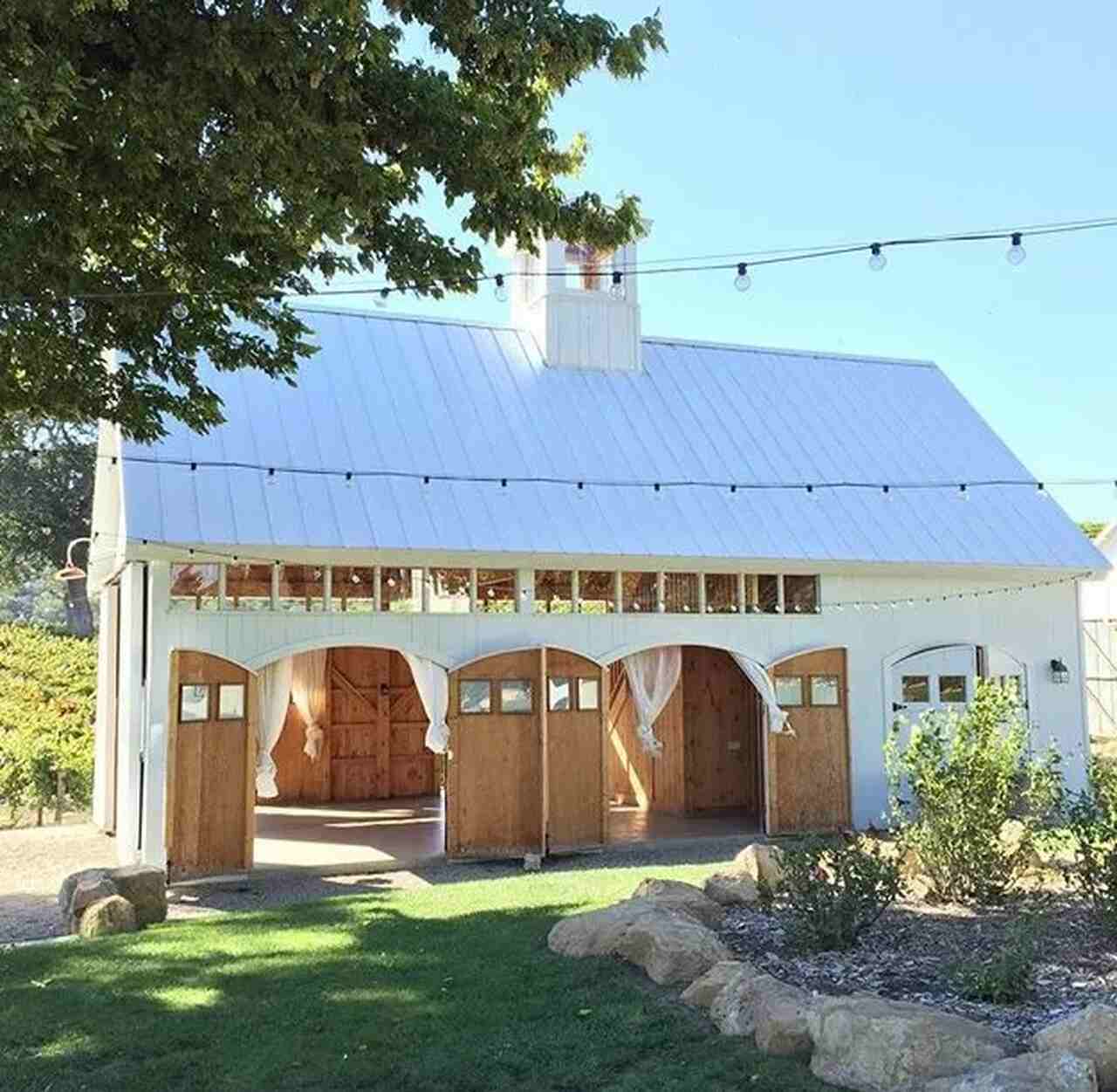 galpão da fazenda decoração para casamento com fios de luzes e tecidos brancos