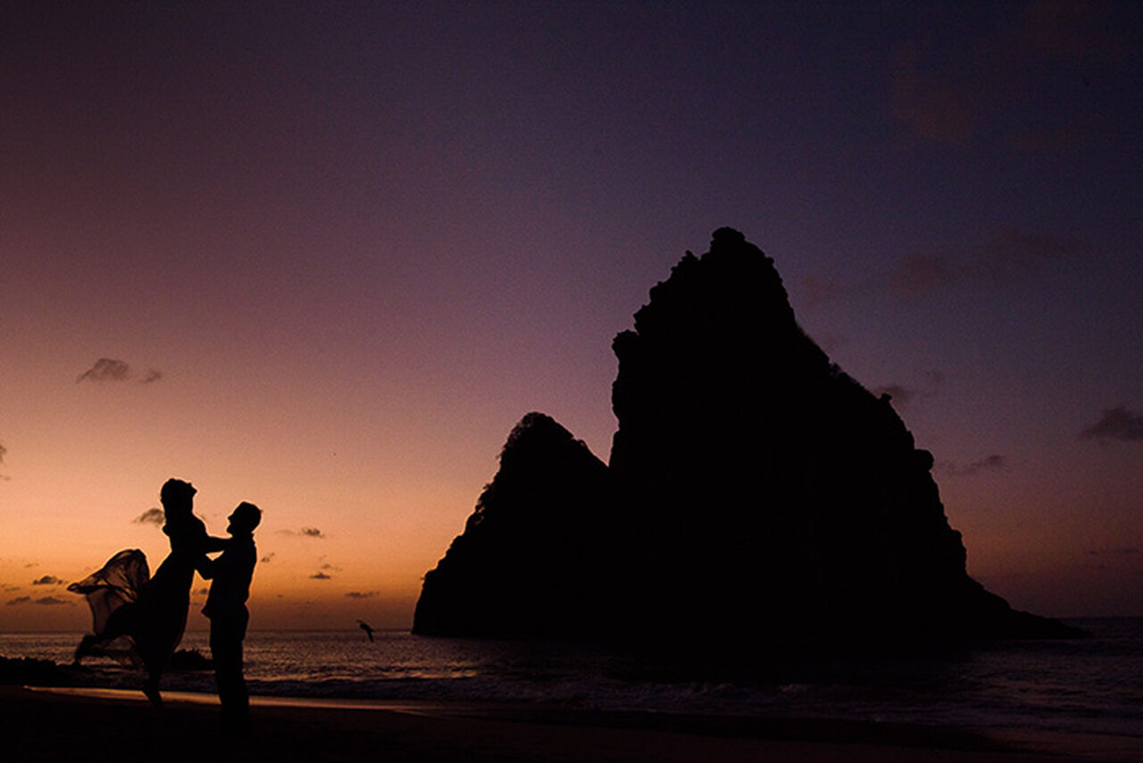 noivos felizes ao pôr do sol na praia