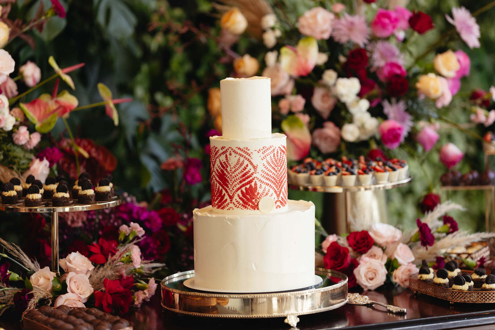 bolo de casamento branco com três andares e detalhes em vermelho