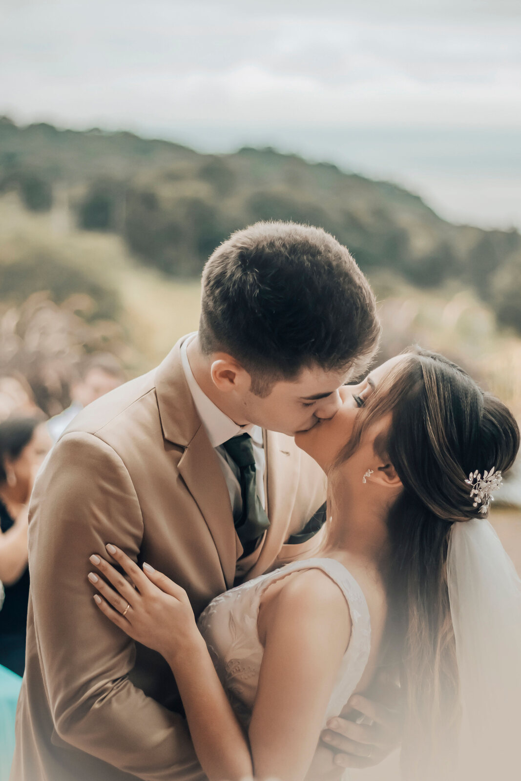 Noiva e noivo se beijam diante da cerimônia de casamento