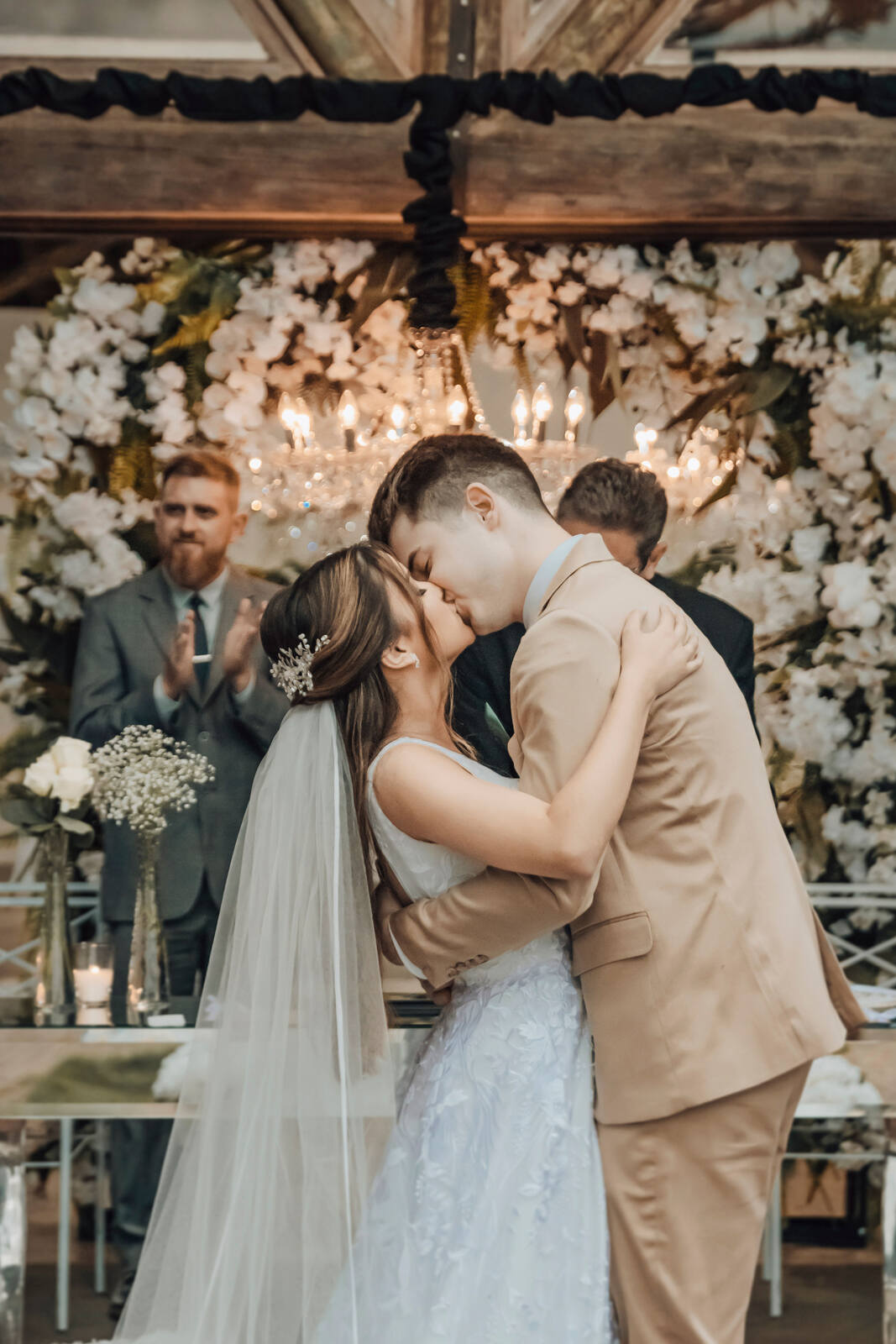 Noiva e noivo se beijam diante da cerimônia de casamento