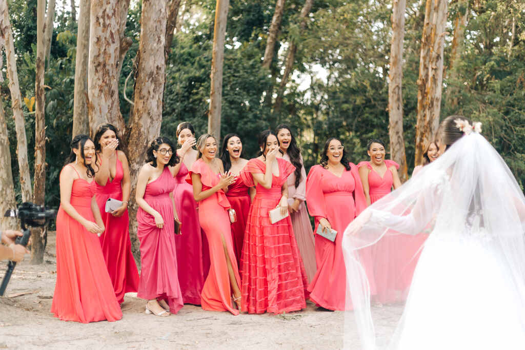 madrinhas de rosa reagindo ao ver a noiva durante o first look