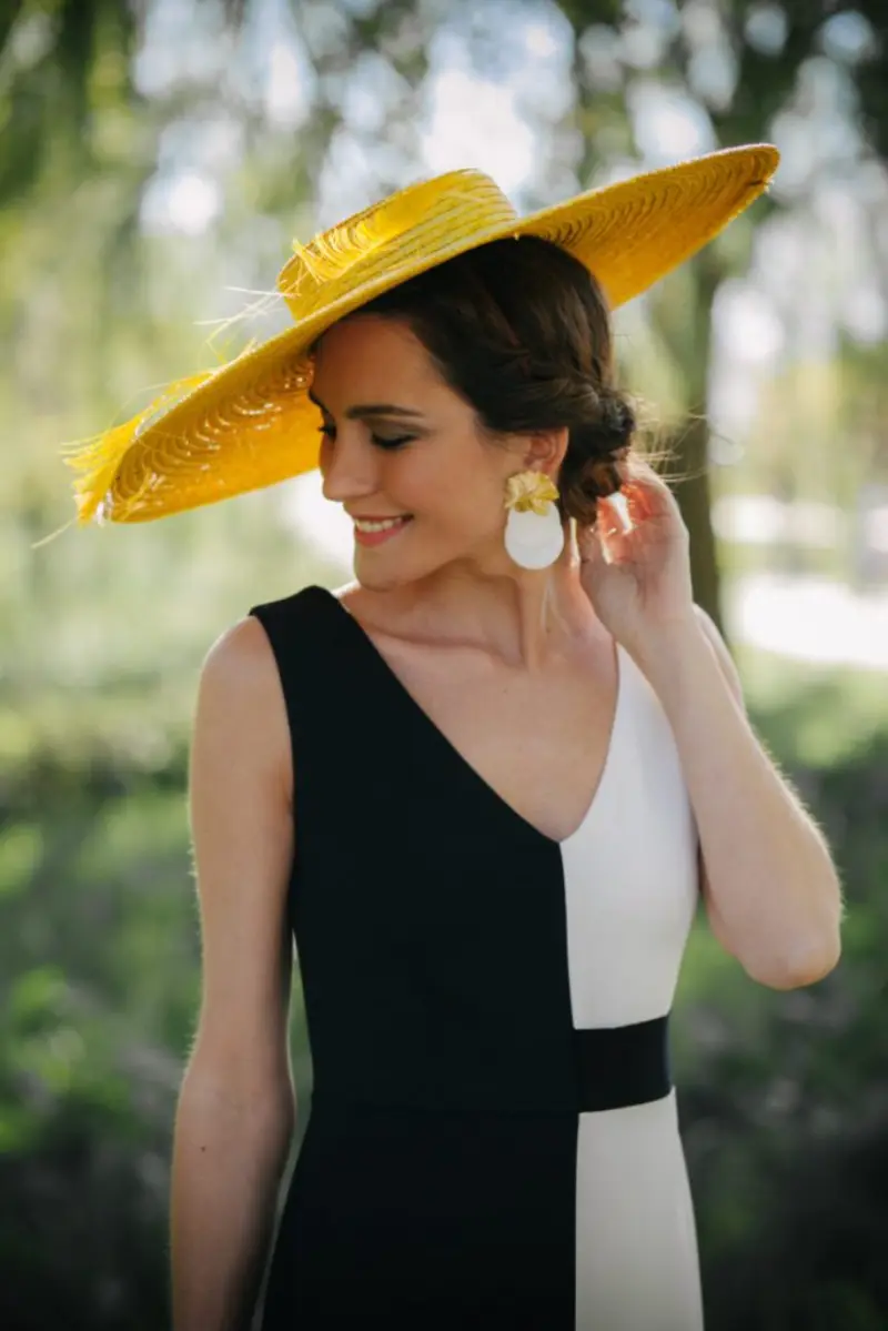 convidada com chapéu para casamento no campo amarelo