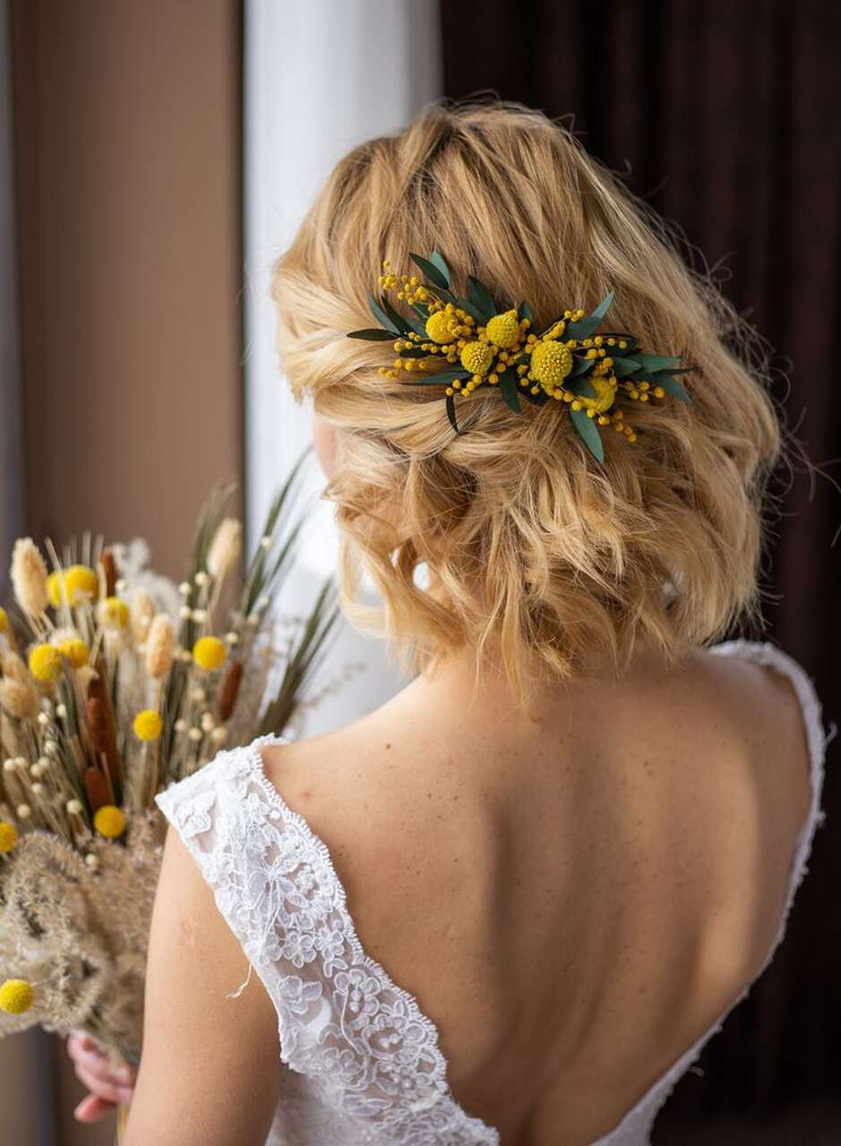 Penteado de noiva com um acessório floral amarelo