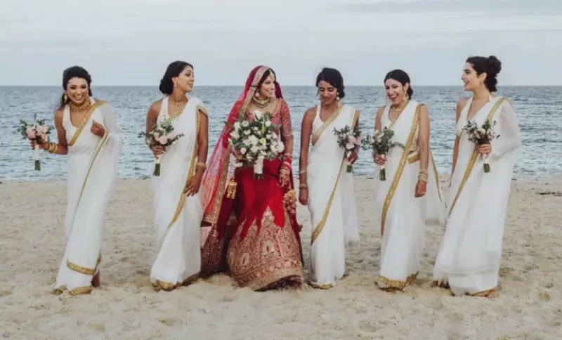 madrinhas caminhando na praia com noiva