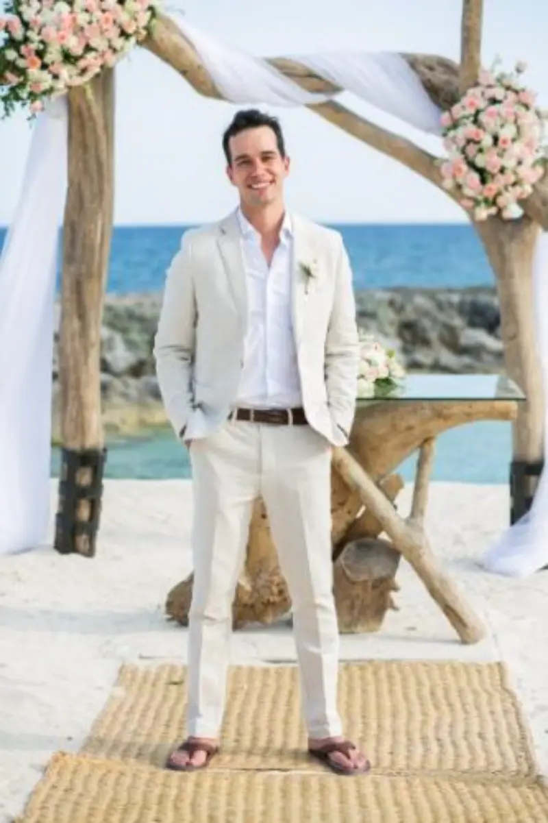 noivo na praia com terno claro