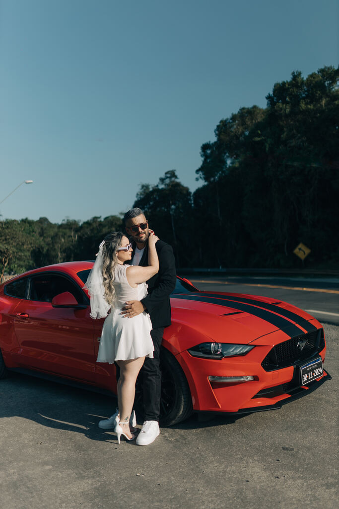 casal abraçado na frente do carro