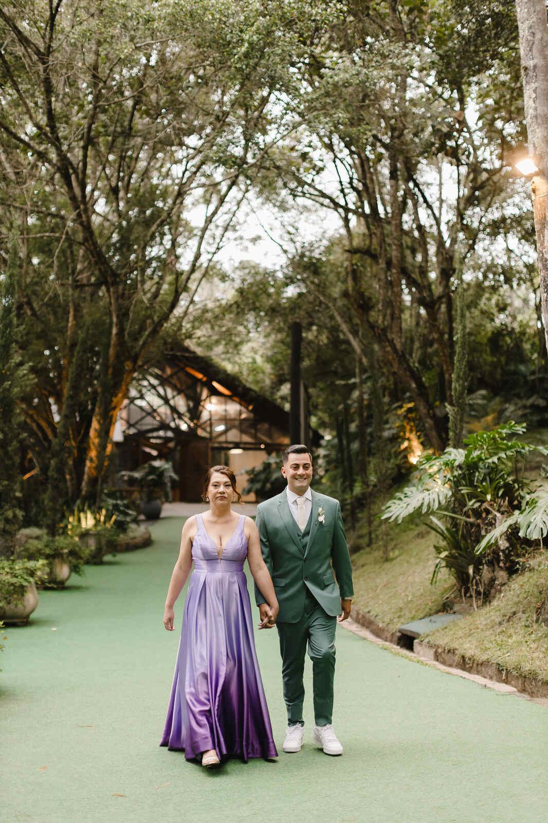 entrada do noivo com terno verde sage com a mãe com vestido lavanda