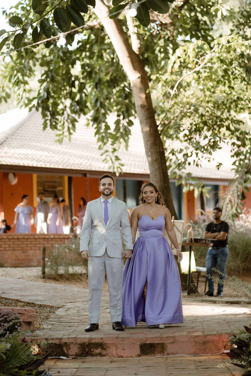 entrada de madrinha com vestido lavanda e padrinho com tenro cinza claro com gravata lavanda