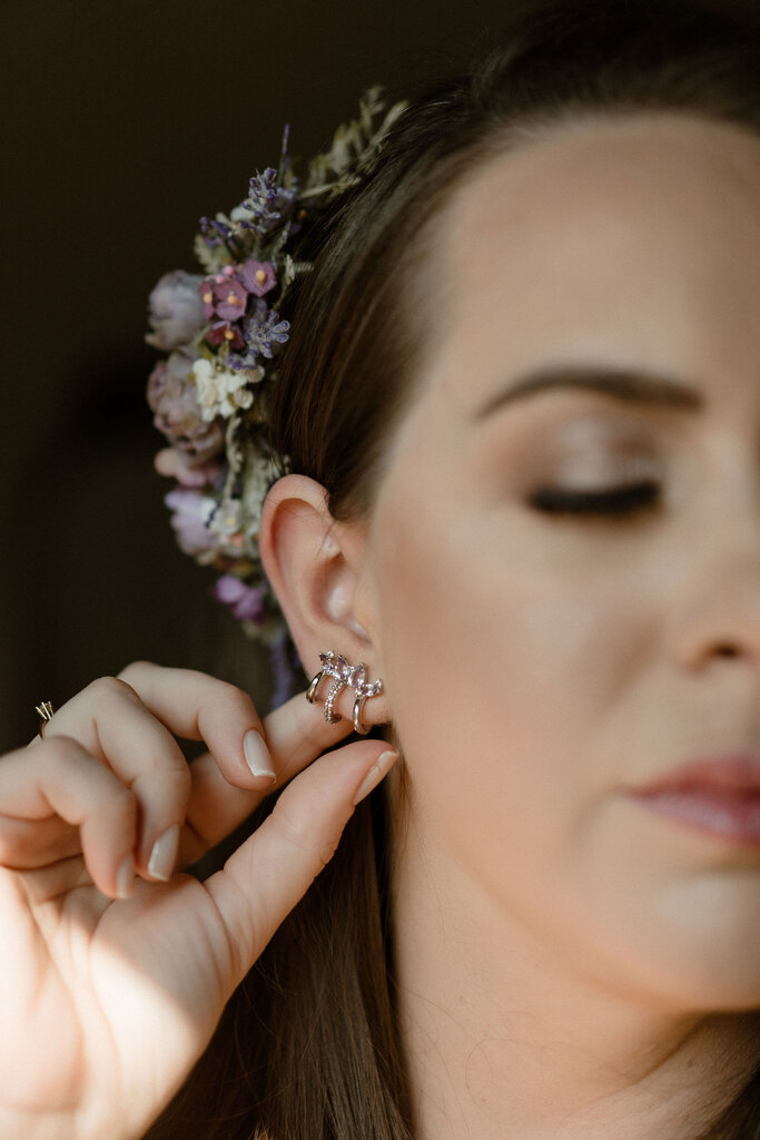 noiva com brinco delicado e flores lavandas no cabelo