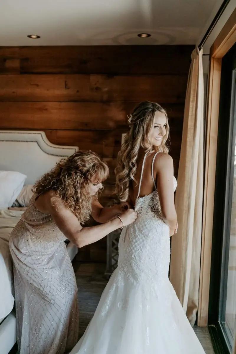 dia da noiva com mãe arrumando o vestido da noiva