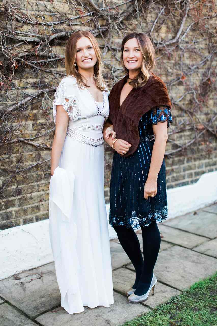 madrinha de casamento com vestido curto meia calça preta e estola marrom