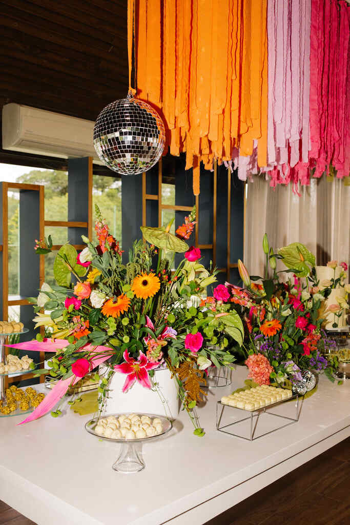 mesa com bolo de casamento e flores coloridas