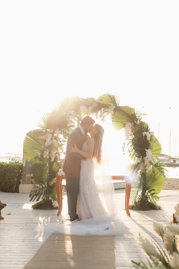 noivos se beijando na cerimonia de casamento na praia