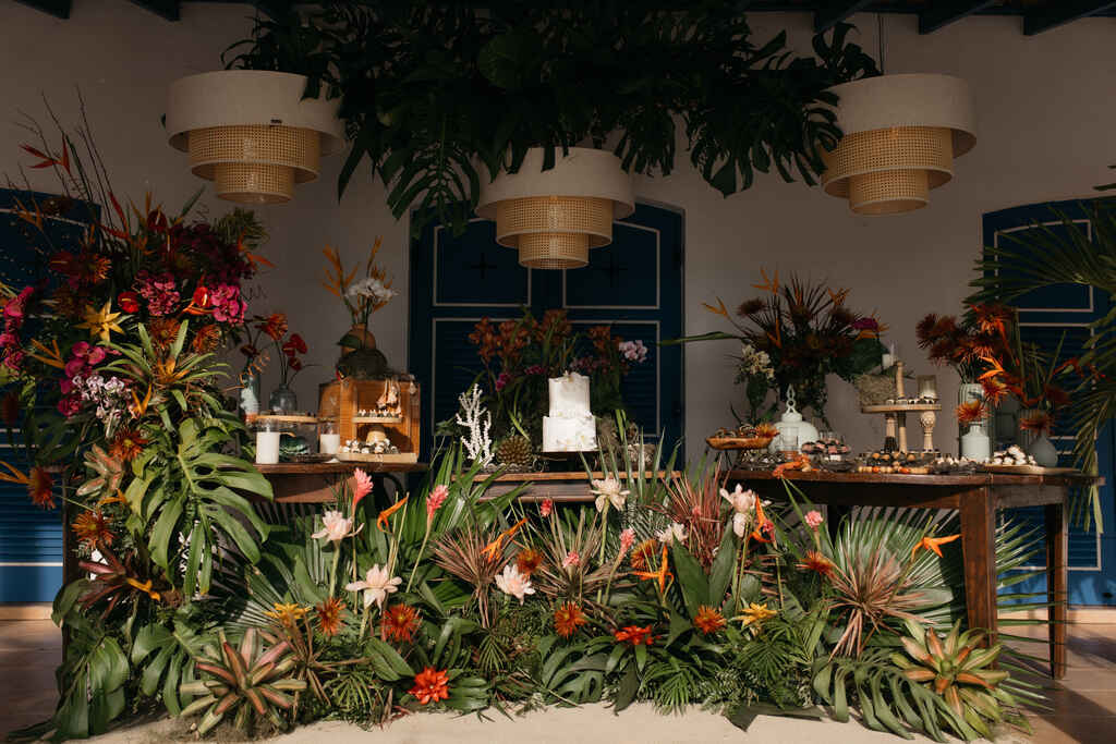 mesa com bolo de casamento com decoração tropical