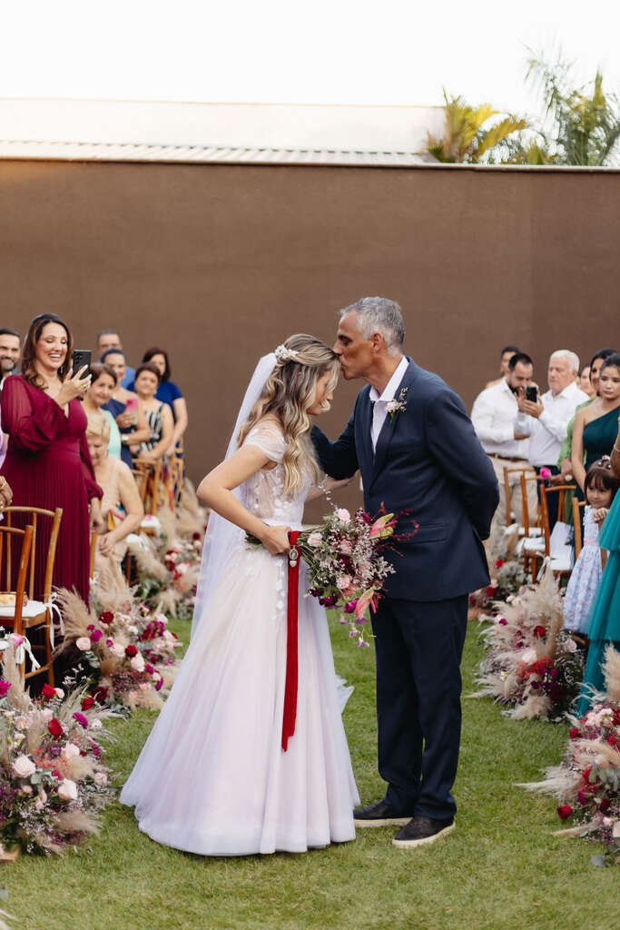 pai da noiva beijando a testa da filha