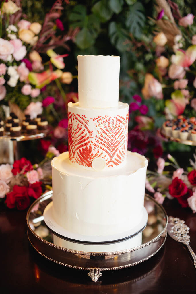 bolo de casamento branco com três andares e detalhes em vermelho