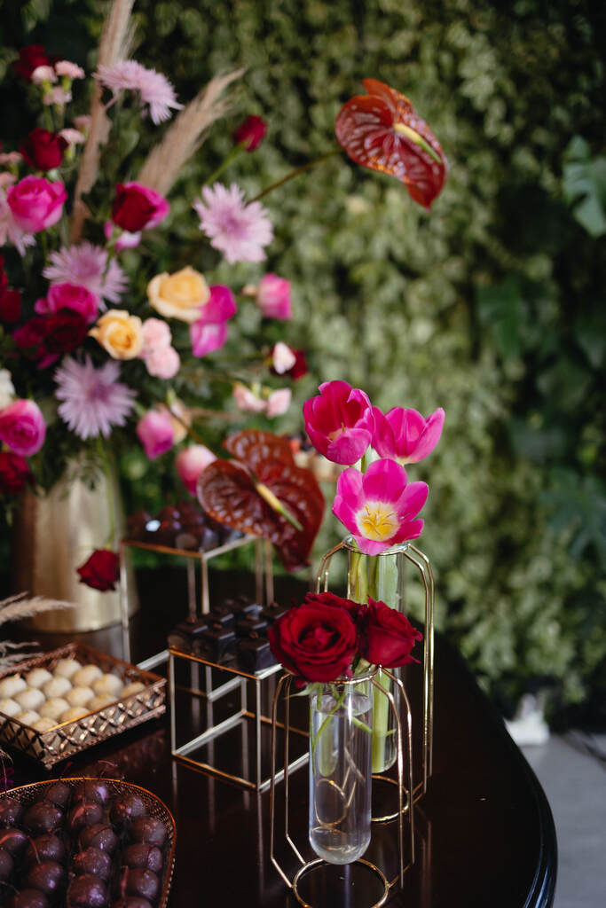 mesa com flores rosas vermelhas e amarelas