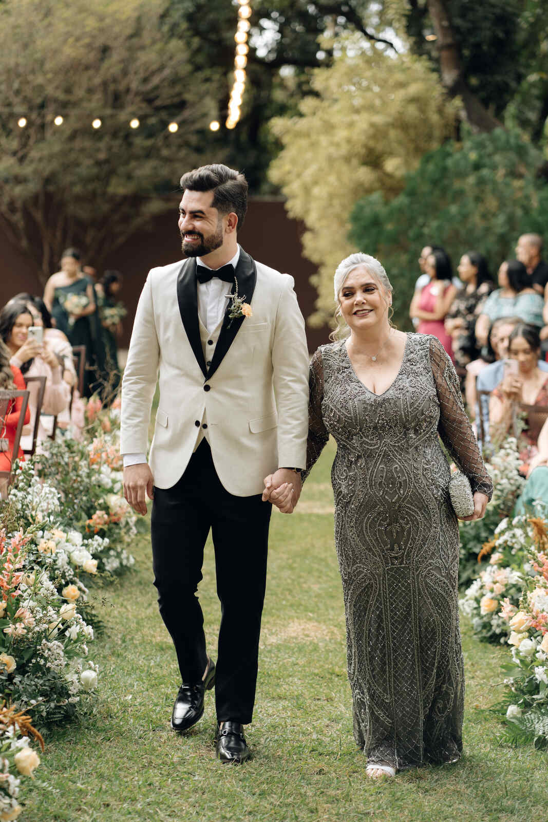 entrada do noivo ao lado da mãe com vestido cinza