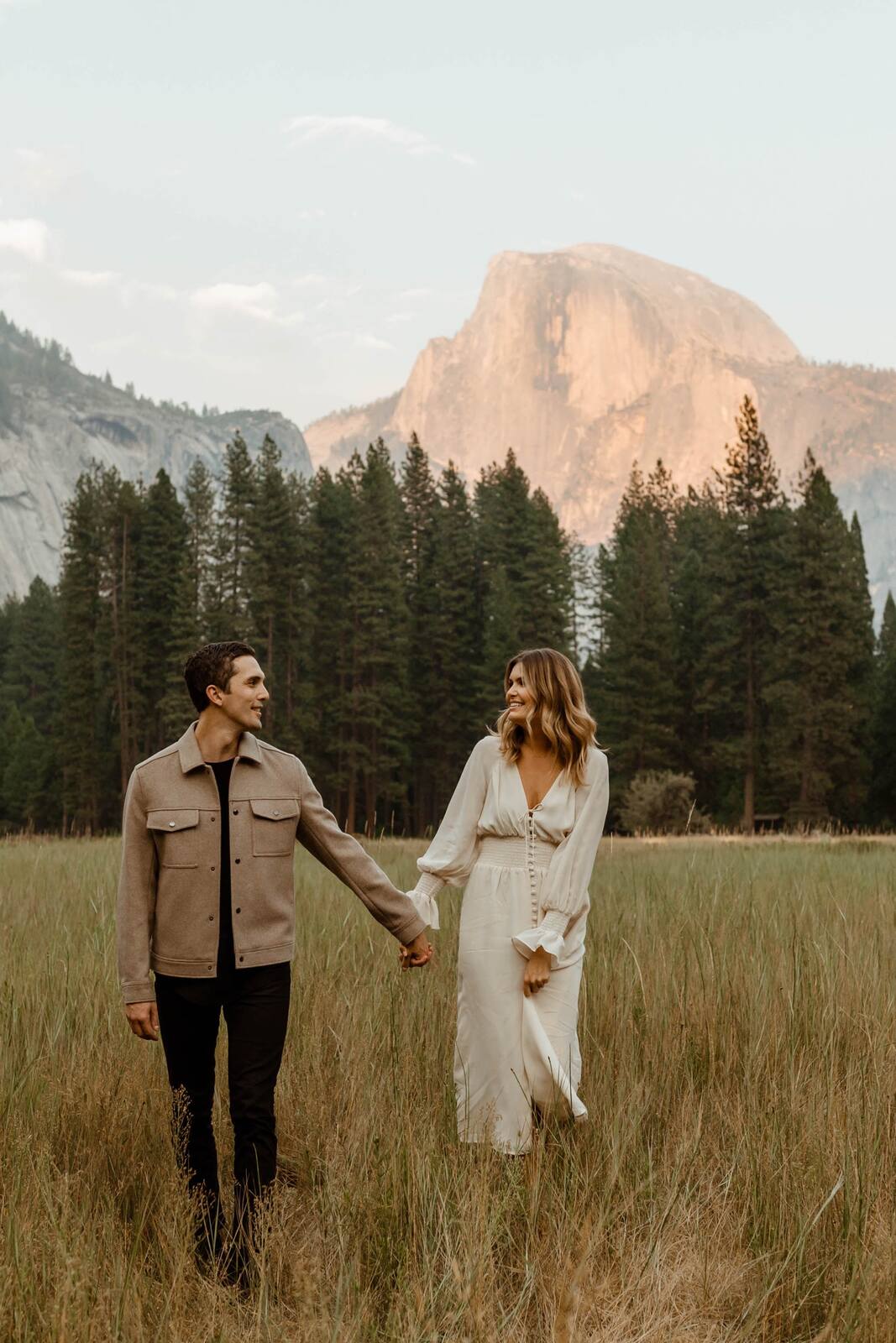 casal no pré wedding no campo com look neutro