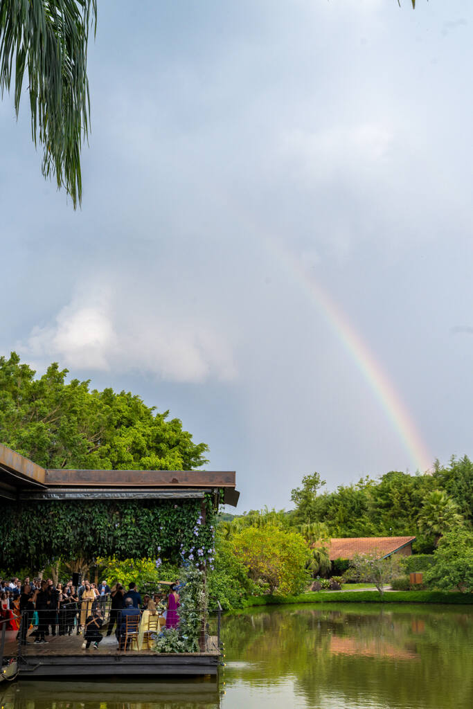 salão de festa a beira do lago e ao fundo arco iris