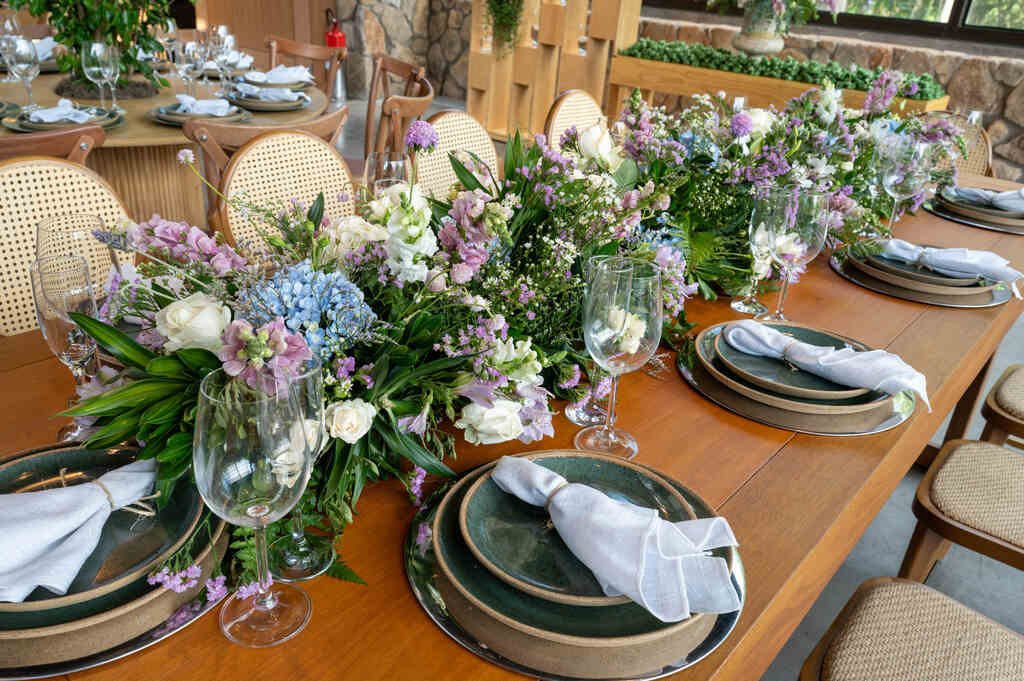 mesa posta com centro de mesa com flores brancas azuis e liláses