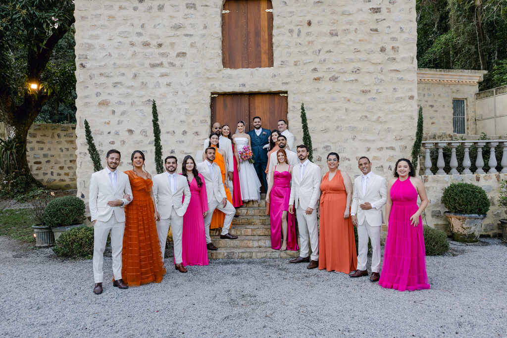 noivos padrinhos com roupa clara e madrinhas com vestidos rosa e laranja