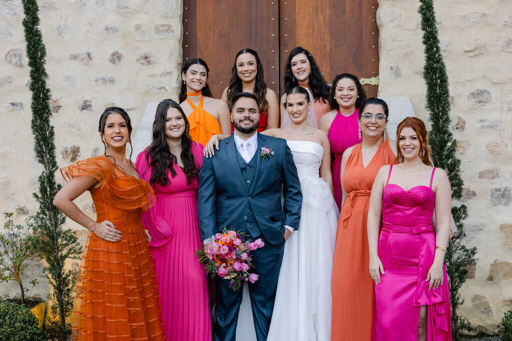 noivos padrinhos com roupa clara e madrinhas com vestidos rosa e laranja