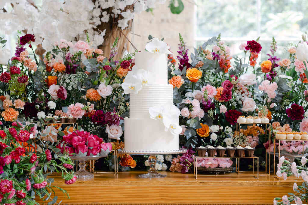 mesa de bolo de casamento com flores coloridas