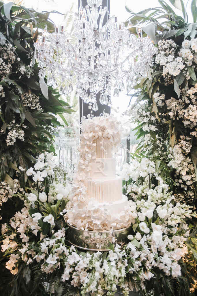 mesa com bolo de casamento e lustres