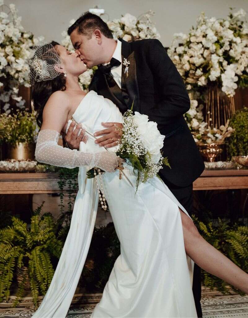 noivos se beijando em frente a mesa de bolo