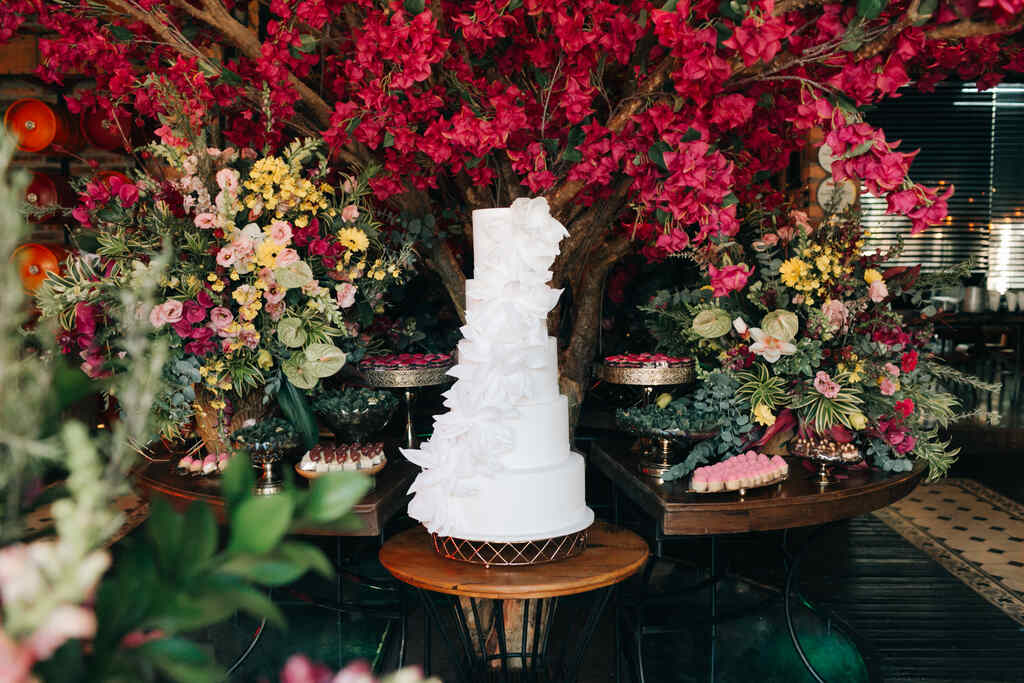 mesa com bolo de casamento branco com flores